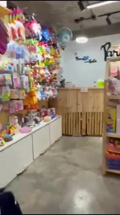 Interior de la tienda con estanterías de madera y el logo en la muralla