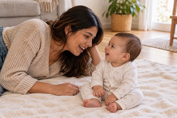 Mamá con su bebé sentado en una manta