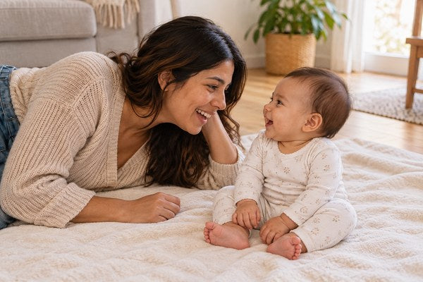 Mamá con su bebé sentado en una manta
