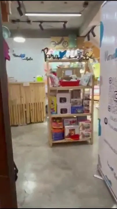 Entrada de la tienda Para su bebé, con ropa de guagua en la vitrina y el pendón de la marca