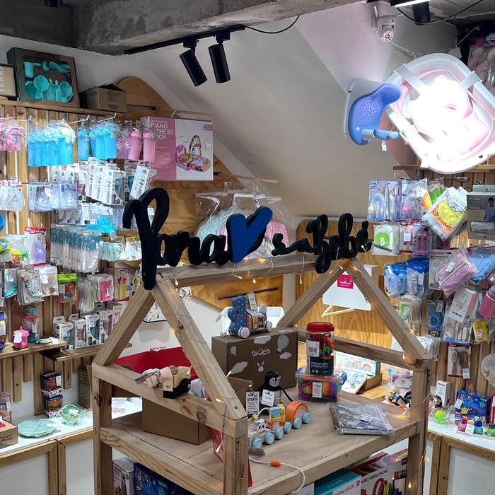 Dentro de la tienda: el letrero de Para su bebé y las paredes con baberos, vasos y mamaderas